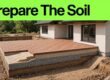 Cutaway patio soil with aggregate, sand, and aligned brick pavers.