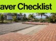 Terracotta pavers are aligned on a prepared patio base beside tropical palms.