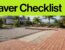 Terracotta pavers are aligned on a prepared patio base beside tropical palms.