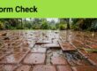 Wet patio pavers have a washed-out joint, scattered leaves, and puddles near a drain.