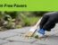 A gloved hand scrapes dried paint from a concrete paver beneath a green banner.